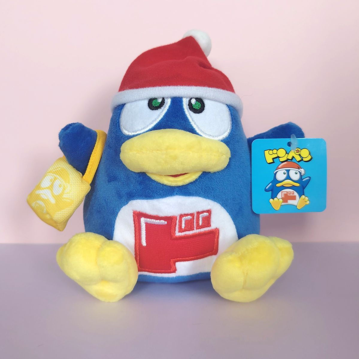 Peluche Donpen de face avec bonnet rouge et sac shopping jaune Donki