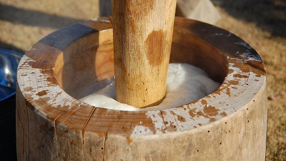 Mochitsuki traditionnel japonais, préparation du mochi en pilant du riz gluant dans un mortier en bois