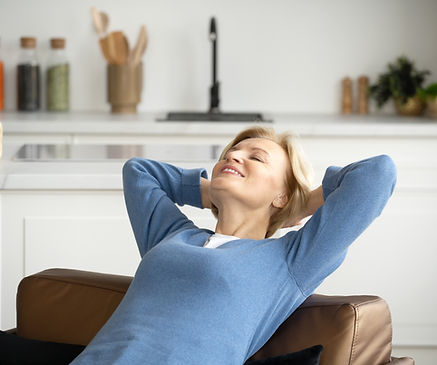 happy a woman sitting on a couch in a living room and relax