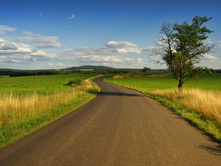 Vue d’une route de campagne bordée d’accotements enherbés, utilisée pour illustrer les éléments accessoires inclus ou exclus du domaine public routier selon la jurisprudence.