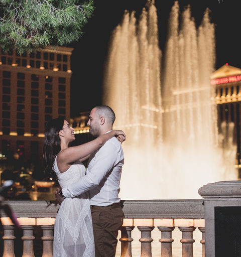 Couple embracing in front of the Bellagio Fountains at night