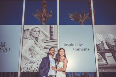 Couple posing in front of Inspired By Moments display