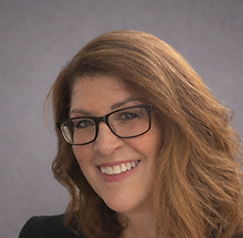 Confident smile in a black blazer.png