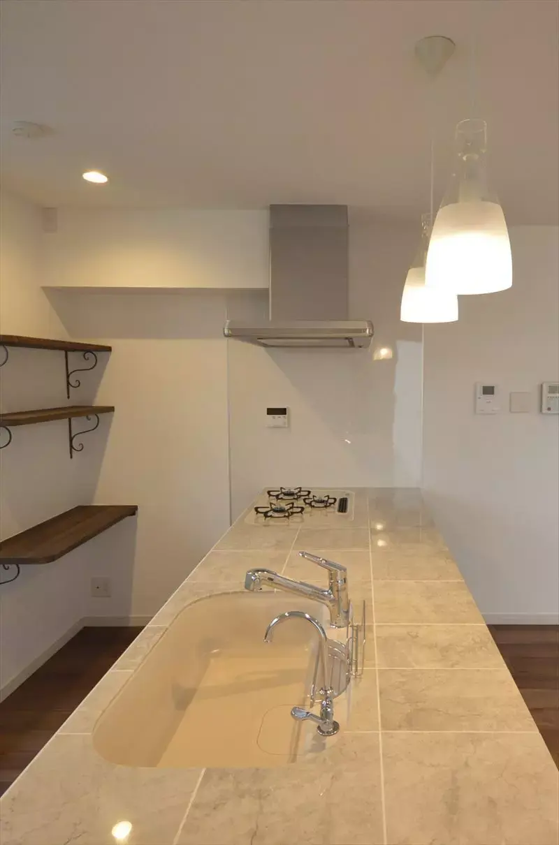 白基調の対面式キッチンの内観