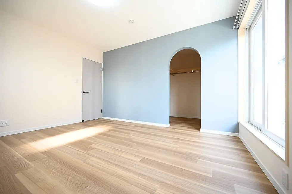 ブルーの建具とクロスが映えるアーチ開口のある寝室