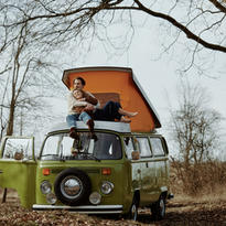 Paar liegt kuschelnd auf grünem Bulli