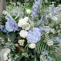 Blumen mit blauen Hortensien und Palmen