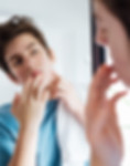 A man inspecting his face in the mirror after cleansing, looking pleased as he examines the results of his skincare routine.