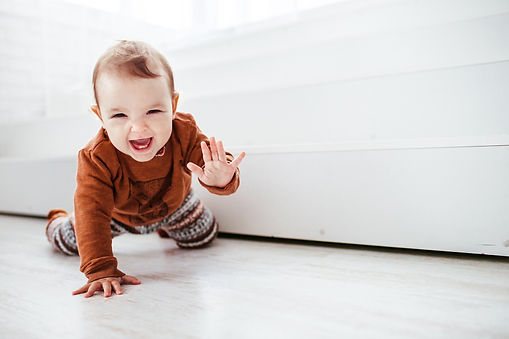 happy-child-orange-sweater-plays-with-feather-floor_edited.jpg