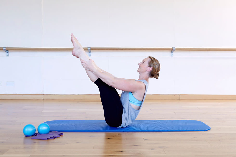 Sasha holding a pilates stretch in her studio