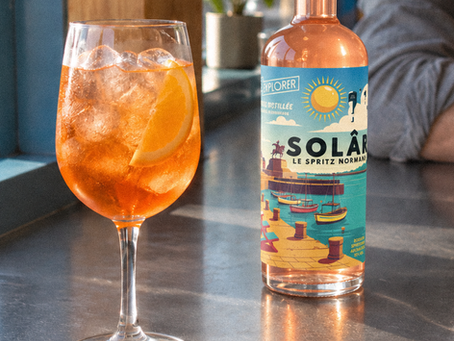 Verre de spritz à l’orange avec une bouteille de SOLÂR, apéritif normand Spirits Explorer