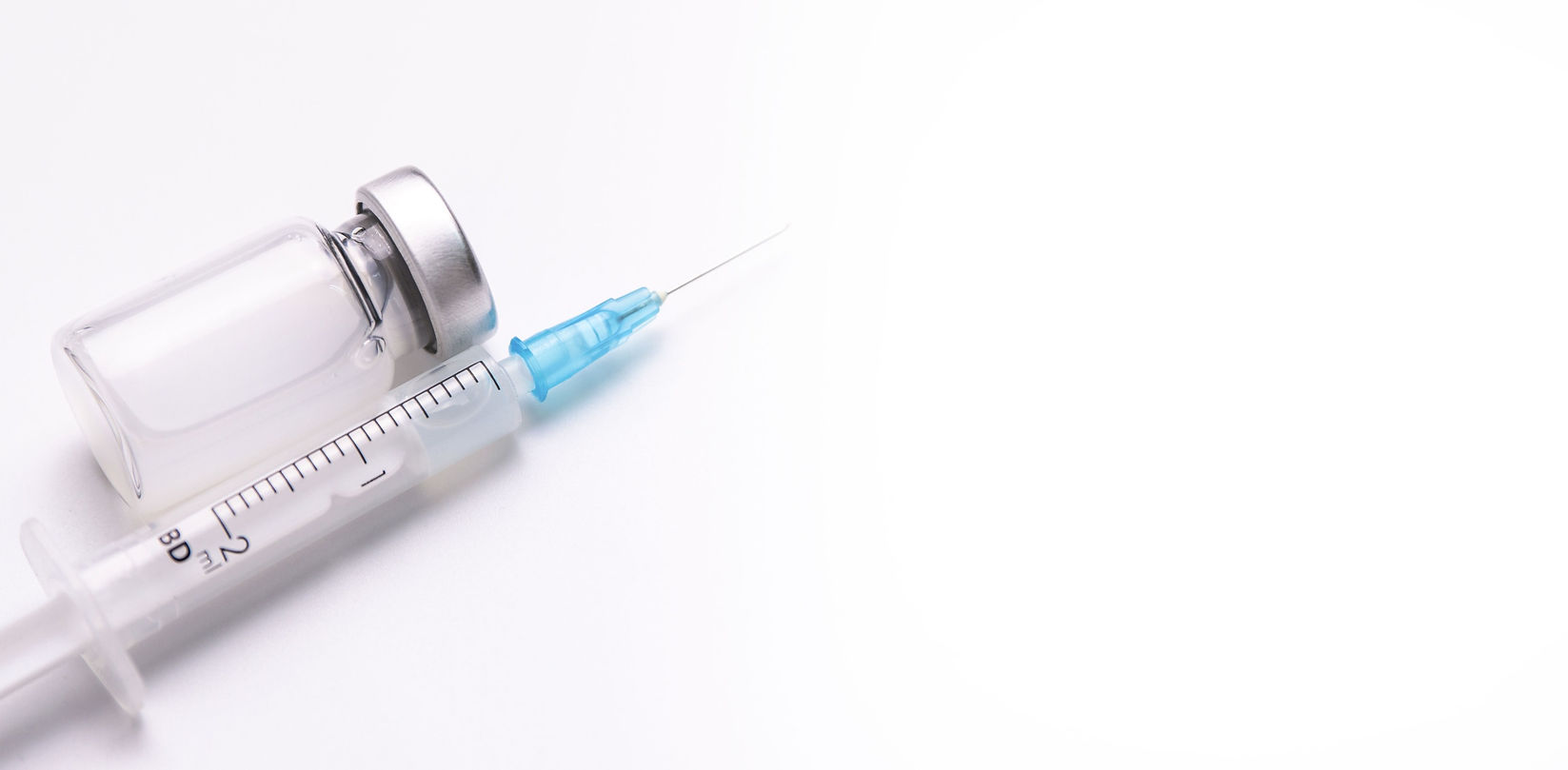 Vaccine bottle and needle next to it