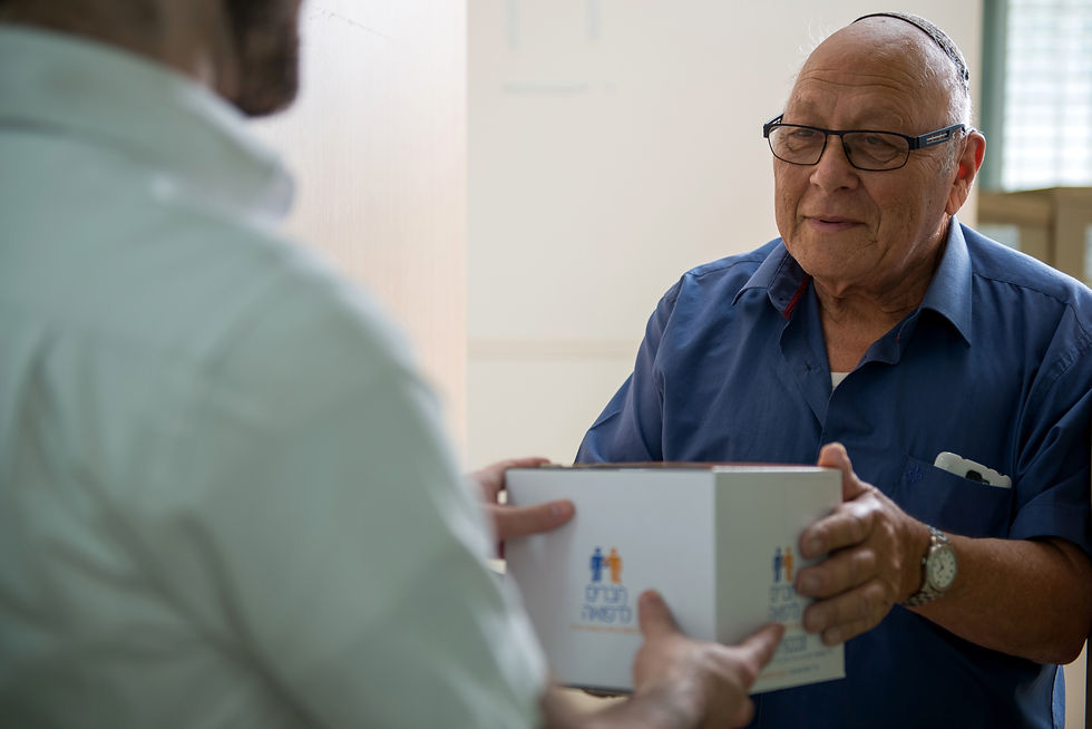 Haverim L'Refuah delivering a box of medicine to an older gentleman
