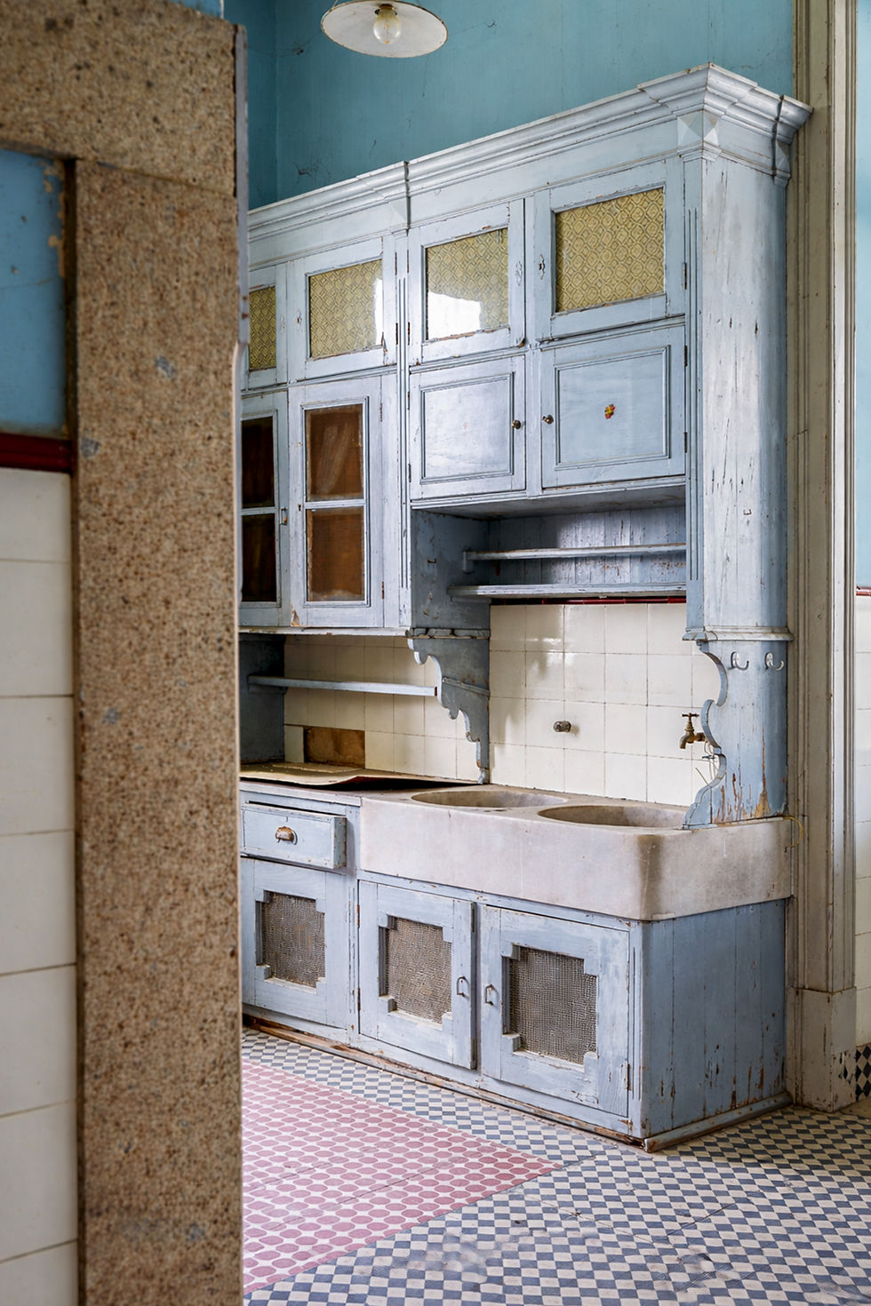 Kitchen with painted wooden cupboards, stone sink and patterned tile floor, manor house in Nisa