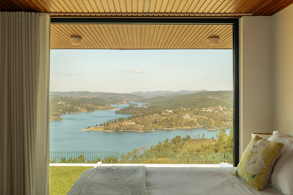 Bedroom with a wide window framing the Castelo de Bode reservoir