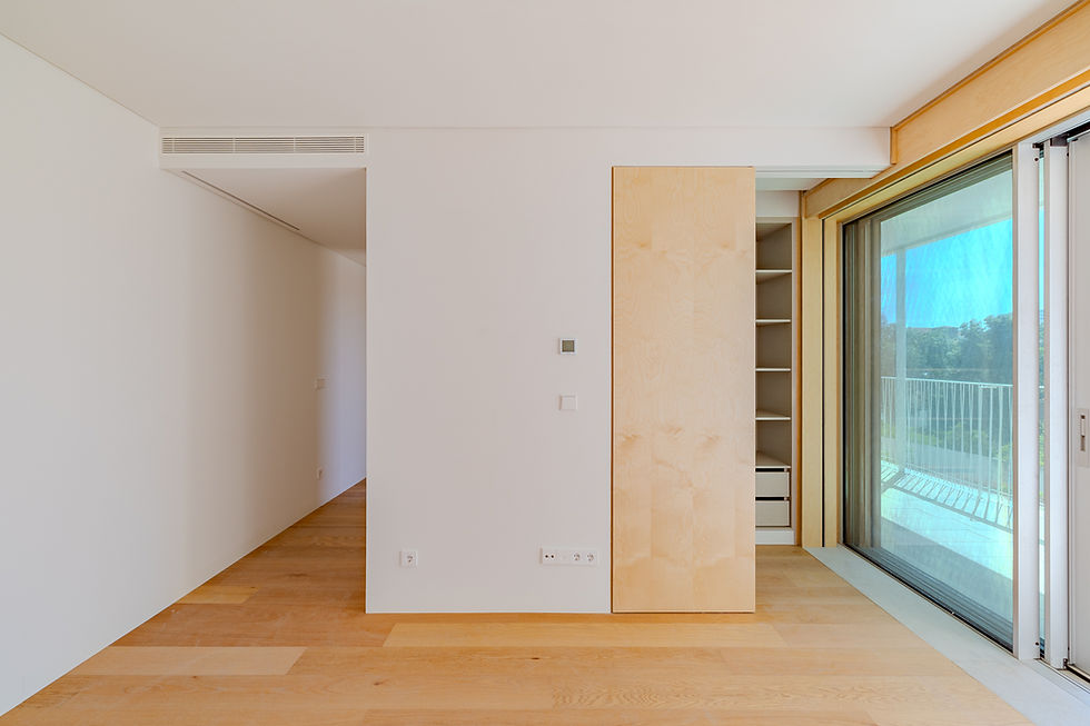 Living room at Santos Dumont 46 with timber floor, pale walls and sliding glazed doors