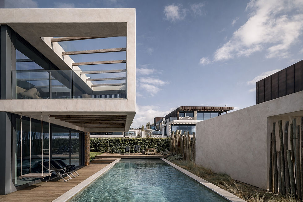 Contemporary house with rectangular outdoor pool, concrete and glass architecture, wooden deck and seamless indoor-outdoor living, located in Santa Cruz near Hotel Areias do Seixo.
