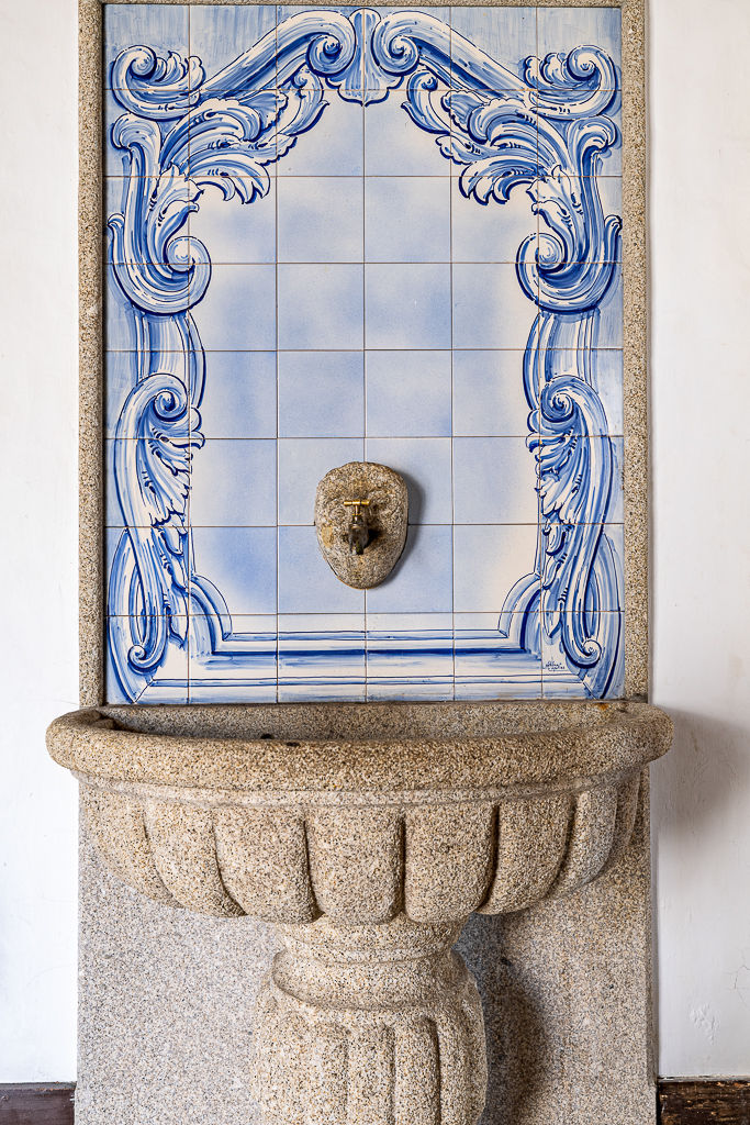 Stone lavabo set against a blue-and-white azulejo panel, former monastery of Vila Boa do Bispo