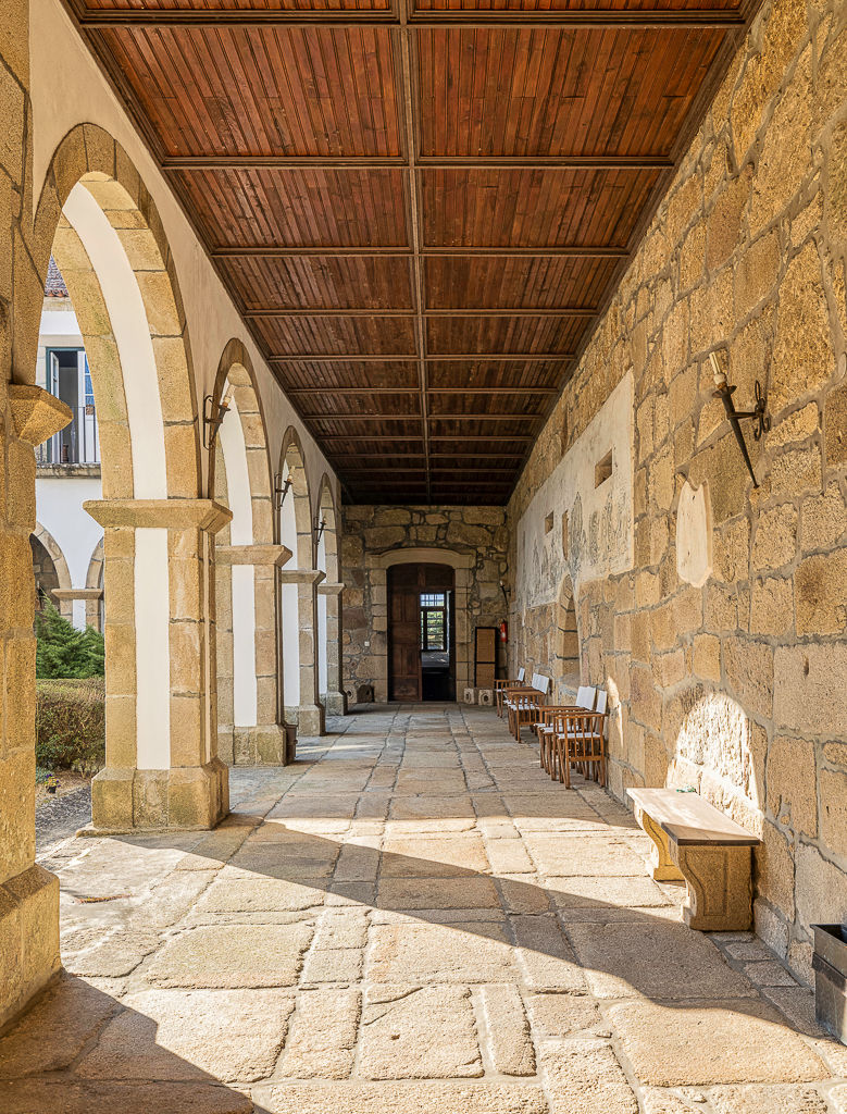 Cloister gallery with coffered wooden ceiling and granite arches, Vila Boa do Bispo