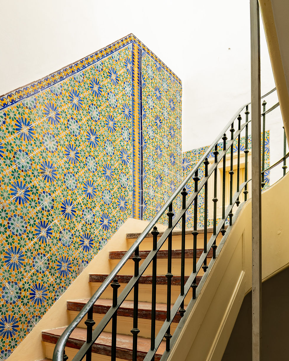 Staircase lined with geometric Lisbon tiles in blue, green and ochre
