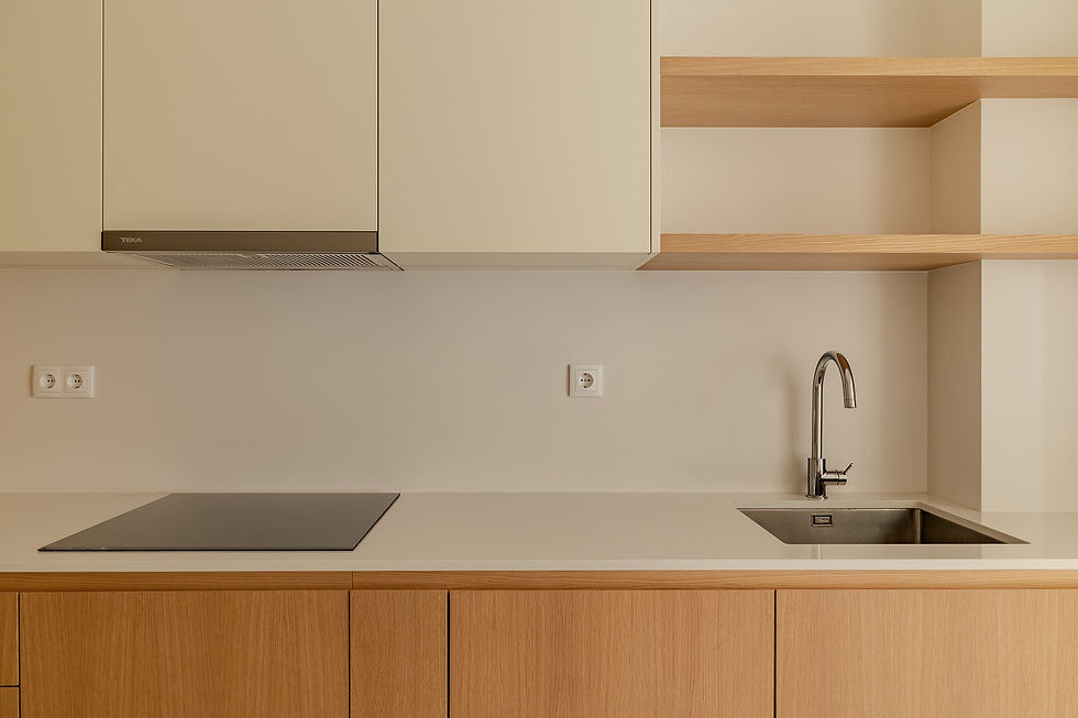 Contemporary kitchen in a three-bedroom apartment in Arroios, Lisbon, with custom wooden cabinetry, integrated appliances, neutral stone countertop, and clean architectural lines.