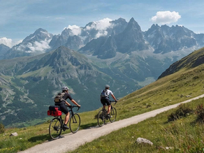 Deux cyclistes sur un chemin au milieu des montagnes