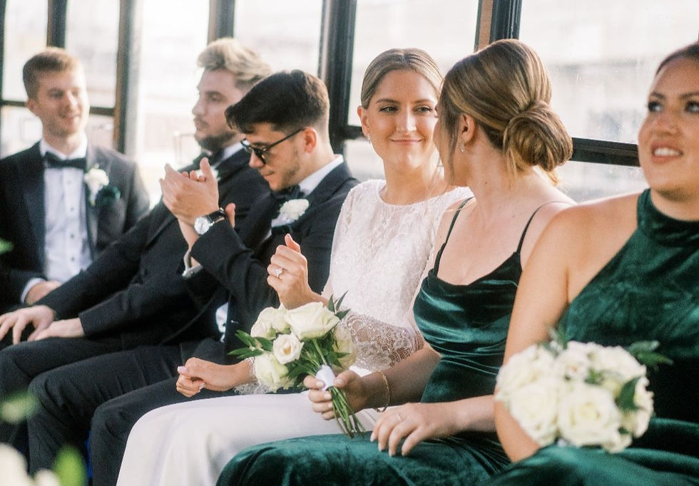 A group of excited and stylishly dressed wedding party members sitting inside a classic white trolley, enjoying the ride while traveling to the ceremony in Miami. The trolley's wooden interior provides a warm and cozy atmosphere, the air conditioning keeps them cool and comfortable, and the smiles on their faces suggest a great time is being had by all. The trolley is an elegant and unique way for the wedding party to arrive at the ceremony in style