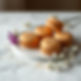 create an image with some caramel color macarons placed on a elegant surface with gold dus