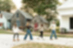 family of four holding hands with dad leading his daughter, then wife, then youngest daughter down the lane of the historic lewes society walk.
