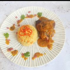 Roasted chicken with a butter chicken sauce served with rice.
