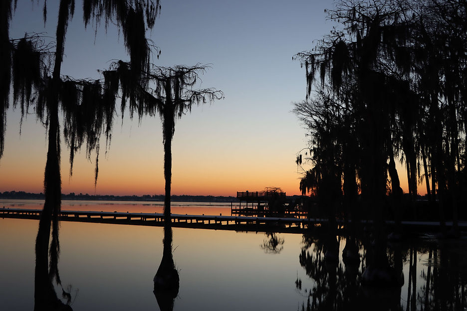 Sunset over a tranquil lake with silhouetted trees