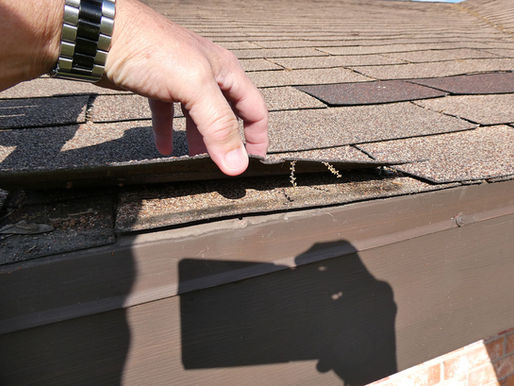 Roof failures and water intrusion caused by lifted and damaged asphalt shingles during roof inspection.