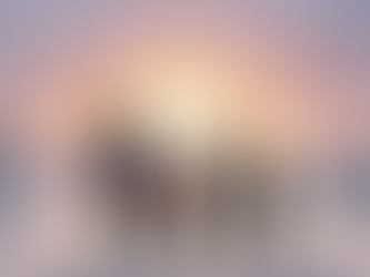 Family of four in winter coats and hats, holding hands, walking in snowy landscape at sunset. Snowflakes fall; a warm, serene scene.