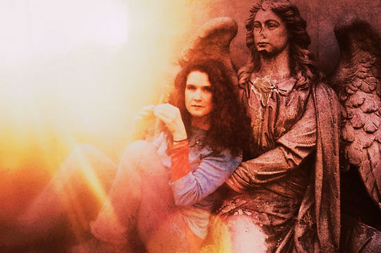 Woman beside a winged angel figure in warm golden light