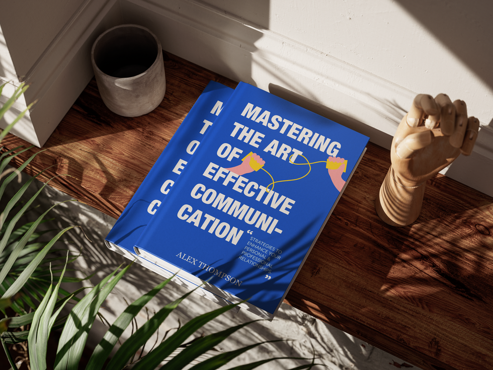 Blue hardcover book titled “Mastering the Art of Effective Communication” by Alex Thompson placed on a wooden floor beside a plant, mug, and wooden hand model.
