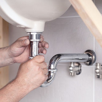 closeup-male-plumber-worker-blue-denim-uniform-overalls-fixing-sink-bathroom-with-tile-wal