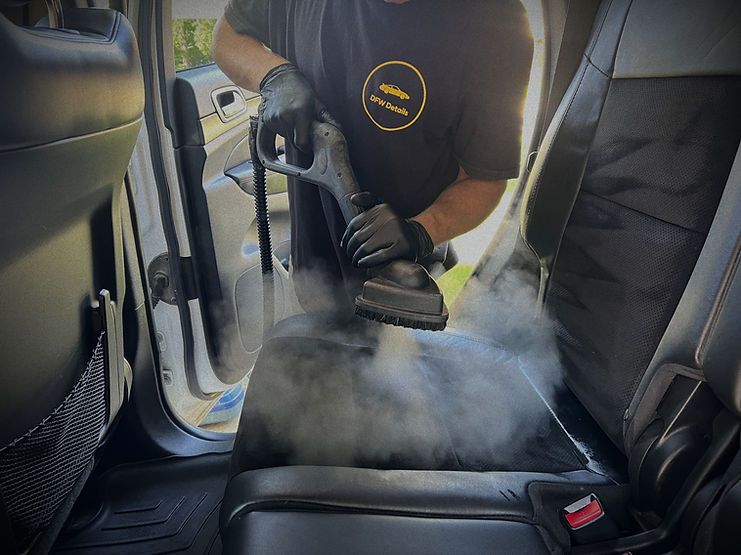 Interior of a Jeep being professionally detailed using steam and shampoo on the seats.