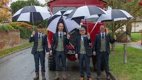 Grooms party with umbrellas and vintage fire engine brave the rain