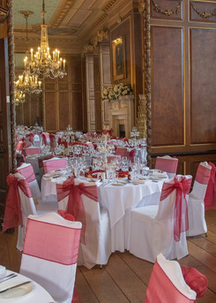 Gosfield Hall decorated in a soft red and white ready for a wedding breakfast