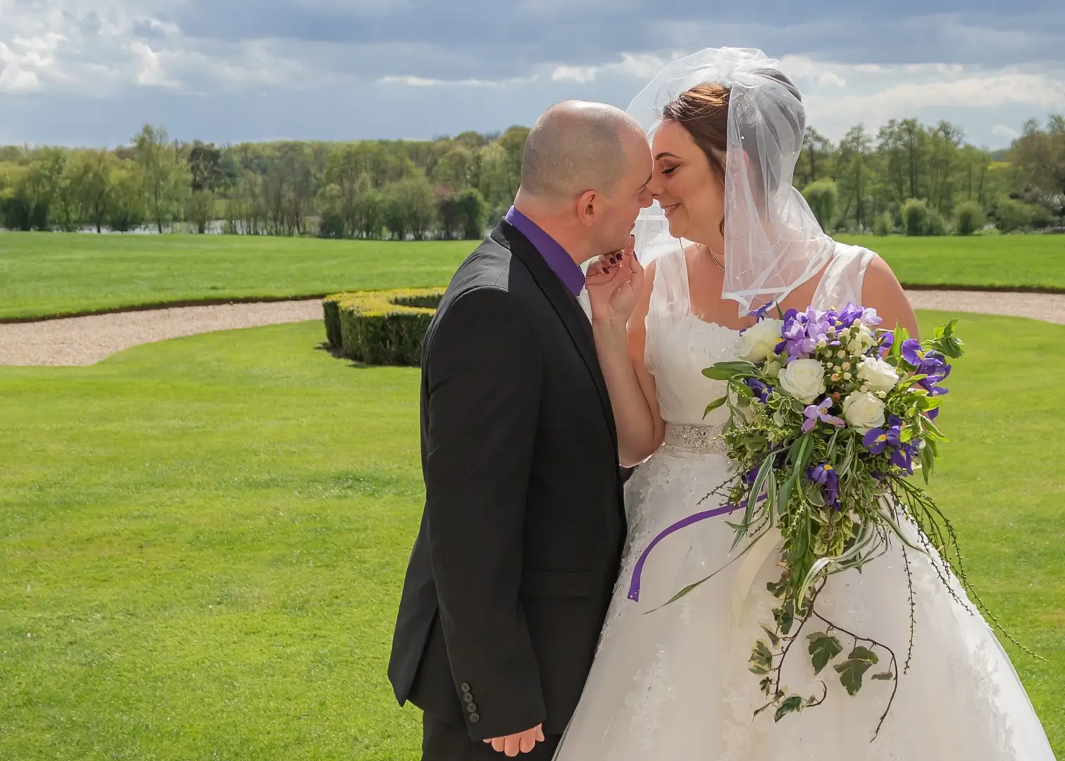 Bride and groom share a tender moment in the grounds of Gosfield Hall