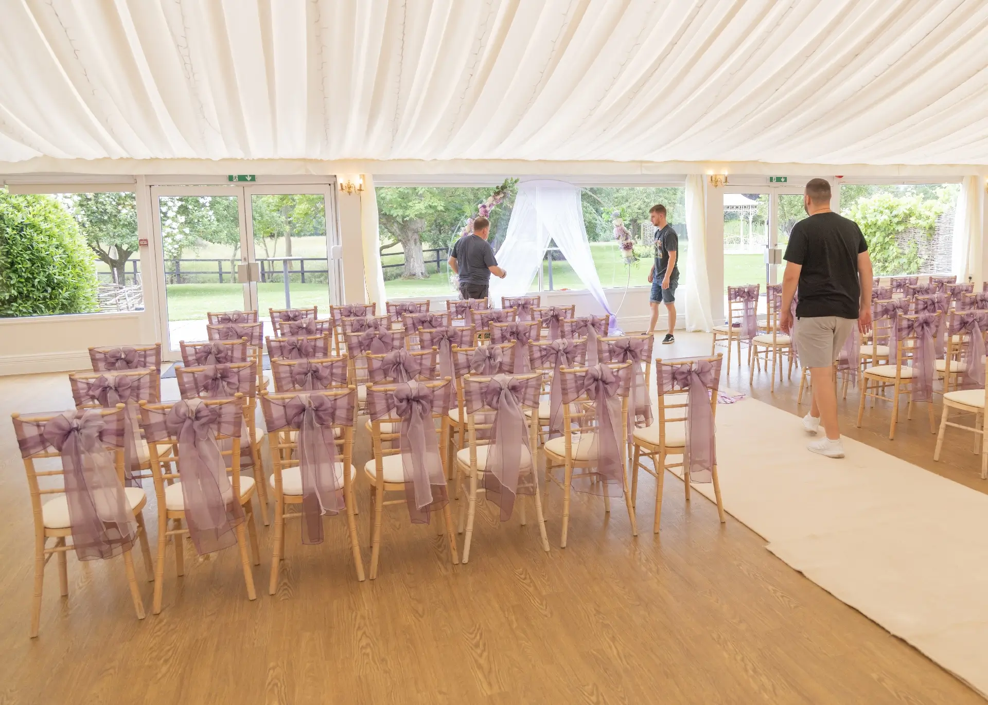 Grooms party setting up the flower arch for the ceremony at The Fennes