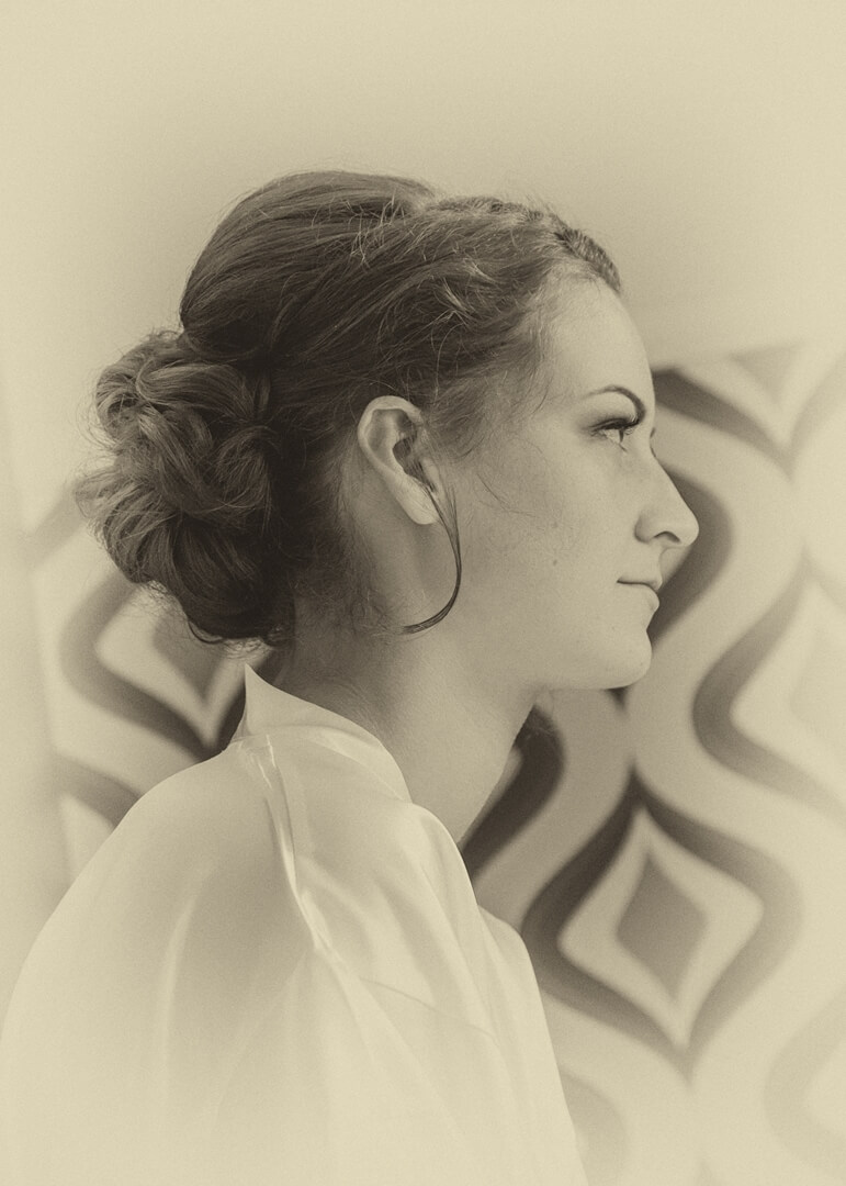 Side portrait of bride in sepia tones during preparations