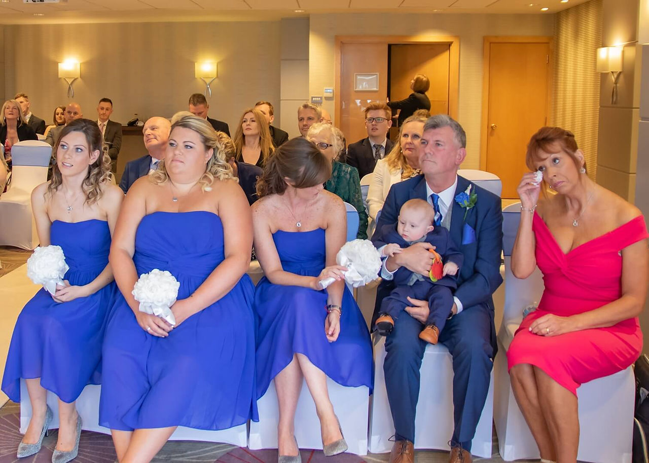 Mother of the bride wipes away a tear during a wedding ceremony at Five Lakes, Colchester