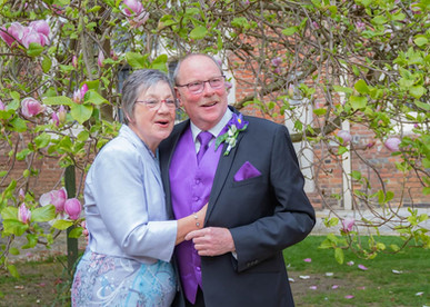 Brides parents in the inner courtyard with magnolia tree at Gosfield Hall