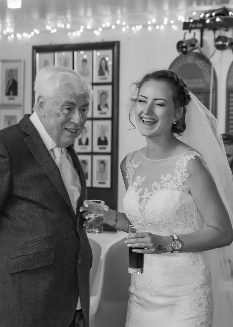 Bride laughs with a wedding guest during her wedding reception at Gosfield Lake Golf Club