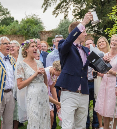 Bride roars with laugter at Great Lodge in Bardfield as she see what her parents gave her groom as a gift