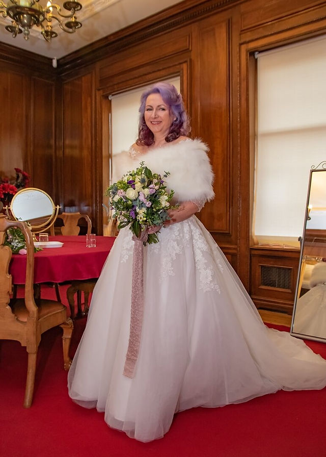 Bride with lilac hair at Braintree Town Hall stands with her spring themed bouquet