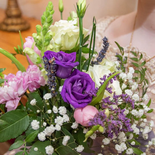 Close up of bridesmaids bouquet held near her lace dress