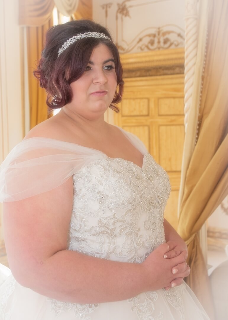 Bride gazing to the side in the gold Rococco suite at Gosfield Hall