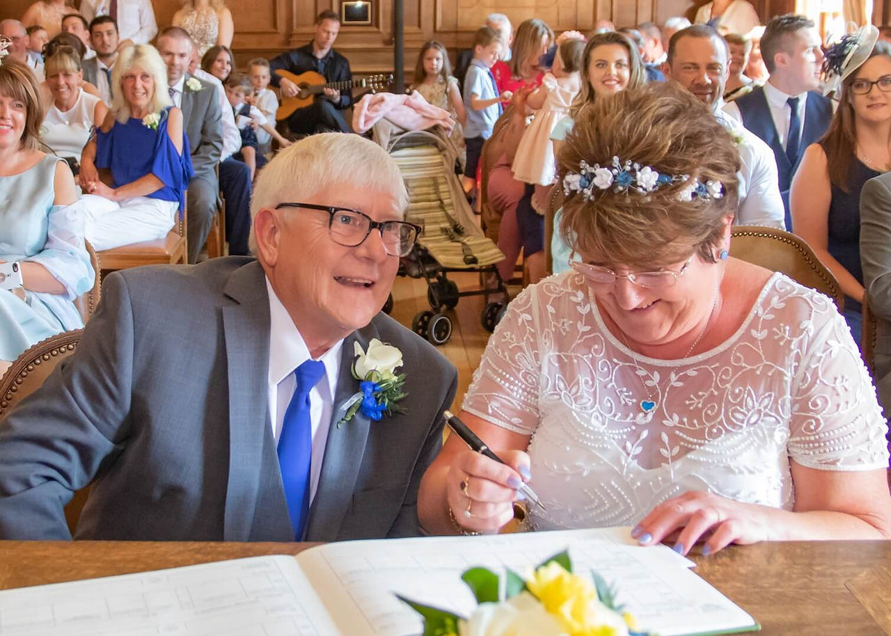 Braintree Town Hall wedding photo of the bride and groom signing the register with all their guests behind them
